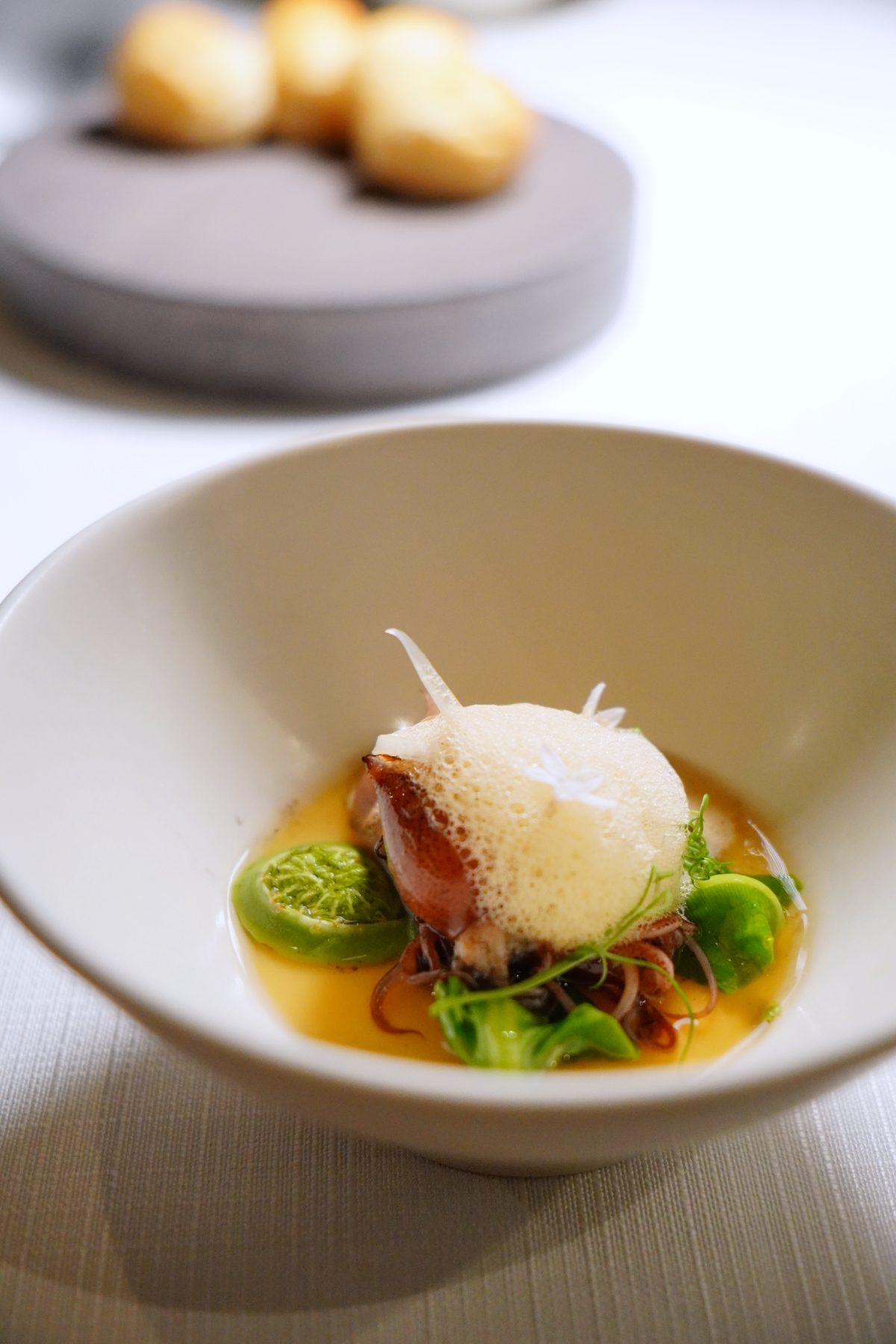 在 Fine Dining 的世界裡，主廚間的客座合作與四手聯彈早已屢見不鮮，不僅帶來話題與媒體關注，更能激盪出料理上耳目一新的火花。台北米其林餐盤推薦餐廳「蘭 Orchid」將於 4 月 26、27 日兩天舉辦四手聯彈晚宴，由主廚 Sato 與現任香港米其林一星餐廳 ÉPURE 主廚、來自新加坡的 Aven Lau 聯手演繹，共同推出一場融合創意與技藝的十道式饗宴，為「蘭 Orchid」注入截然不同的風貌。 料理中藏著兩位主廚的對話 這次的四手聯彈並非簡單的個人特色料理拼盤秀，而是由 Sato 與 Aven 共同設計，將雙方擅長的食材與手法融入每一道菜。像是「靜岡×花蓮蕎麥麵｜鮑魚｜春筍」這道，便以「蘭 Orchid」原有的蕎麥麵為基底，結合 Aven 對於鮑魚處理的想法，以清酒、燒酒與紹興酒煨煮後，搭配春季當令竹筍與枸杞，創造出既熟悉又新穎的口感與風味。 依舊不錯過Chef Aven的招牌風格 作為來自 ÉPURE 的米其林一星主廚，Aven 當然也帶來幾道完整展現他料理哲學的代表作品。例如開胃小點「北海道海膽｜菊芋」，先將菊芋磨粉烘乾後製成如糖脆的外殼，包覆入口即化的海膽，口感與層次之間形成精彩對比。 另一道「鰤魚｜墨西哥辣椒｜紫蘇」，則運用墨西哥辣椒製成微辣醬汁，搭配紫蘇香氣、鰤魚生魚片與蘿蔔絲，賦予刺身料理趣味十足的變奏感。這些菜色不僅展現了 Aven 對風味的拿捏，也體現他遊走於法式精緻與亞洲食材之間的創作語言。 十道料理中藏滿亮點與巧思 在整套十道式料理中，還有不少令人期待的亮點。例如「富山螢烏賊｜X.O.｜山野時蔬」，以螢烏賊為主角，搭配由近 30 種海鮮邊料熬製而成的清湯，呼應主廚 Sato 對食材永續利用的理念。湯面輕覆一層 XO 醬泡泡，為這道料理增添視覺與味覺的海味層次。 另一道「彰化胭脂鴨｜香菇｜日式雞肉丸」，則將胭脂鴨熟成超過三週後風乾，料理後外皮酥脆、內裡仍保有肉汁，一口咬下，鴨油香氣瞬間在口腔中迸發，與日式風味的雞肉丸與香菇相互呼應，形成飽滿而和諧的主菜風格。 限時登場，兩日限定的味覺交響 「蘭 Orchid」主廚 Sato Kiyoshi 與香港 ÉPURE 主廚 Aven Lau 的四手聯彈客座晚宴，僅於 4 月 26 日與 27 日登場，提供十道式料理，套餐價格為 NT$6,880，另可加購 4～5 款搭配氣泡酒、清酒及紅白酒的餐酒組合，完整體驗料理與酒款的美味對話。
